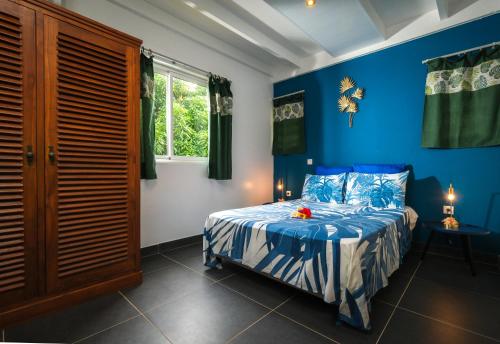 um quarto azul com uma cama e uma janela em POELANI em Faaone