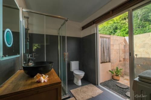 a bathroom with a black sink and a toilet at POELANI in Faaone
