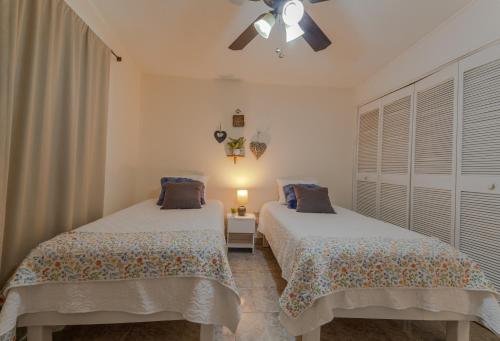um quarto com 2 camas e uma ventoinha de tecto em Casa Elefante hermosa y Centrica em Chihuahua