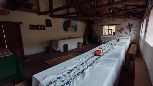 a long bed in a room with a table at PONDOWASI LODGE in Ibarra
