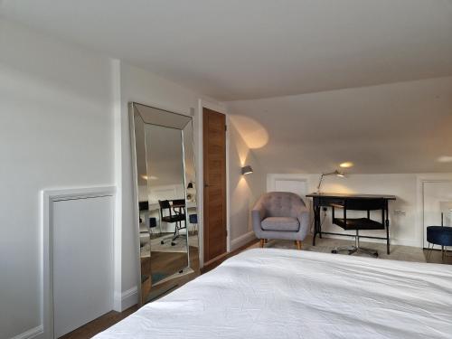 a bedroom with a bed and a desk and a mirror at Luxury London Oasis in London