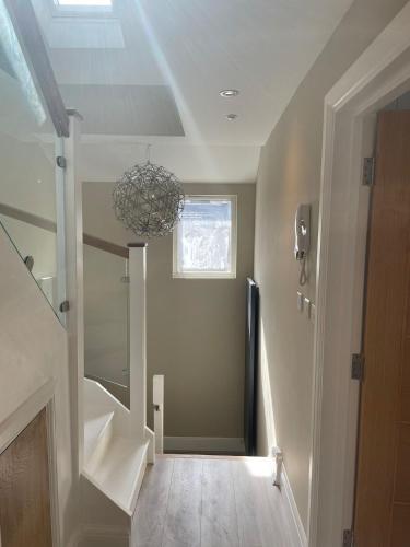 a hallway with a staircase with a chandelier at Luxury London Oasis in London
