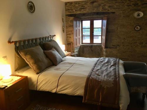 een slaapkamer met een groot bed en een raam bij Casa da Forxa, renovated former forge/ smithy in Lugo