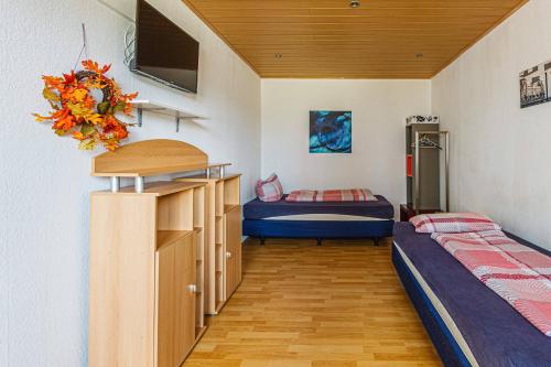 Habitación con 2 camas y TV en la pared. en Gemütliche Monteurwohnung in Sandersdorf en Sandersdorf