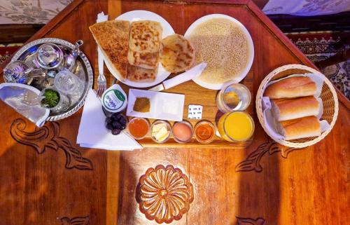 a wooden table with bread and other food on it at Riad Sibari in Meknès