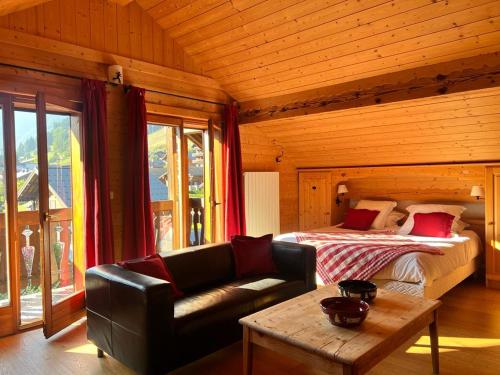 a bedroom with a bed and a couch and a table at Fleur des Neiges in Morzine