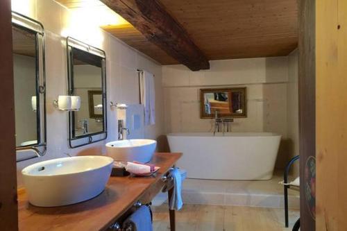y baño con 2 lavabos y bañera. en Les Quatre Saisons - balcon et jardin, en Val dʼIlliez