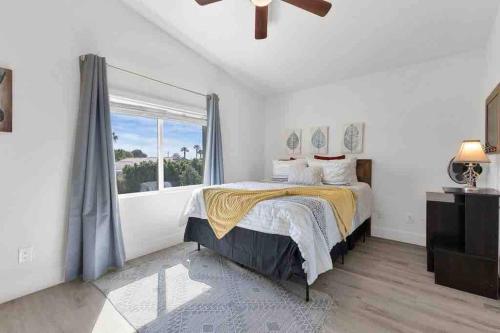 um quarto com uma cama e uma grande janela em Bermuda Fun Oasis em Bermuda Dunes