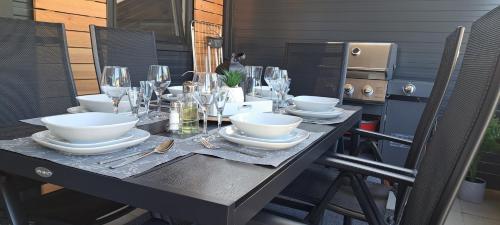 a table with plates and bowls and wine glasses at Mobilna kućica 146 Harmony in Privlaka