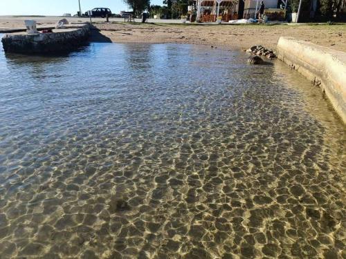 a body of water with some rocks in the water at Mobilna kućica 146 Harmony in Privlaka