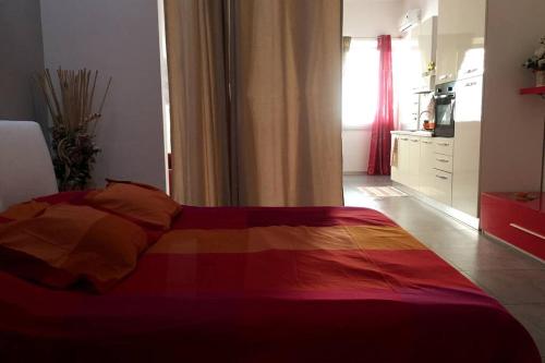 - une chambre avec un lit et une couverture colorée dans l'établissement Loft con ampia terrazza a 500 MT da Piazza Bovio., à Piombino