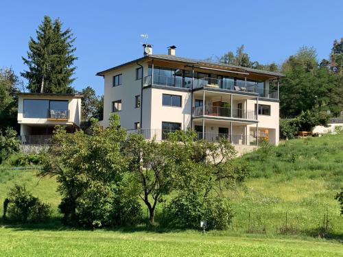 a house on top of a hill with a tree at Residence Villa Schlern in Fiè
