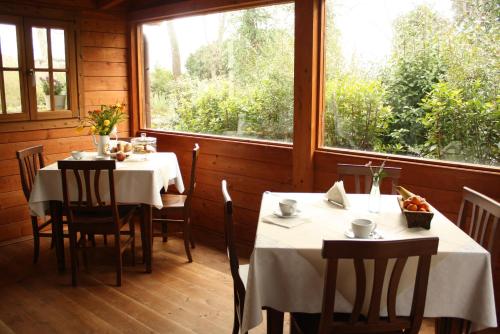 jadalnia z dwoma stołami i dwoma oknami w obiekcie Conca Marina w mieście Tempio Pausania