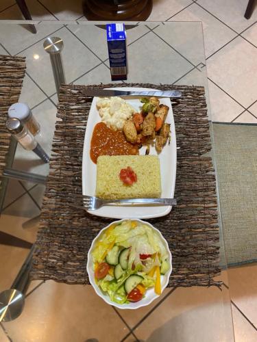 a table with a plate of food and a bowl of food at Siena Sun Guesthouse Rooms and Breakfast Option in Midrand