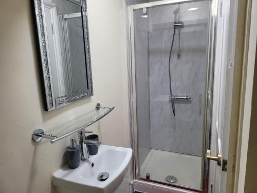 a white bathroom with a shower and a sink at Lovely 1-Bed Studio in Reading in Reading