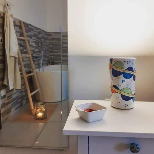 a bathroom with a table with a vase on it at B&B Suite Vela Bianca in Salerno