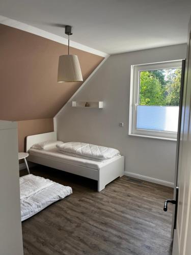 een zolderkamer met 2 bedden en een raam bij Hochwertiges Haus mit Garten mit guter Anbindung in Berlijn