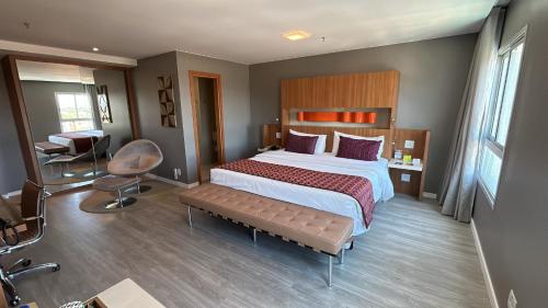 a bedroom with a bed and a desk and a chair at Jade Hotel Brasília in Brasilia
