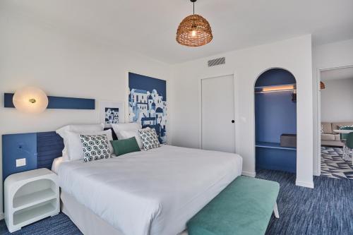 a bedroom with a large white bed and blue walls at Appart Hotel Odalys City Marseille Centre Euromed in Marseille