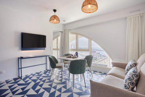 a living room with a table and chairs and a tv at Appart Hotel Odalys City Marseille Centre Euromed in Marseille