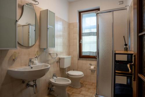 un bagno con lavandino, water e specchio di VIVI SERENO, uno stile si vita! a Grosio