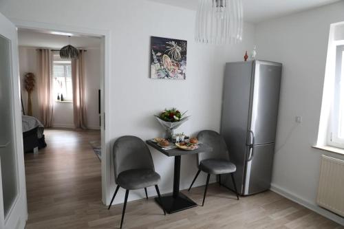 ゾーストにあるSoester Altstadt Apartmentのテーブルと椅子と冷蔵庫のあるキッチン