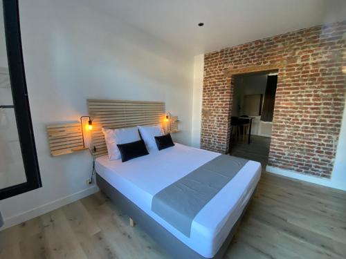 - une chambre avec un grand lit et un mur en briques dans l'établissement Namur BnB, à Namur