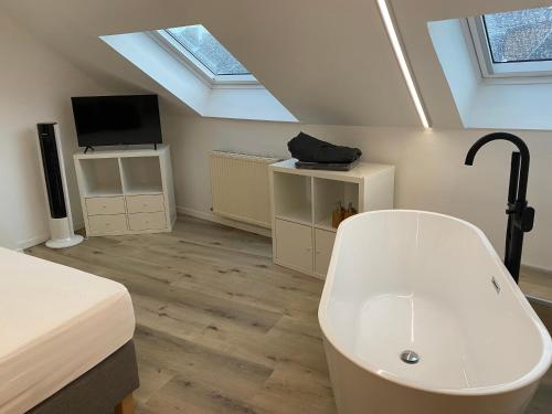 een slaapkamer met een bad, een bed en een tv bij Namur BnB in Namen