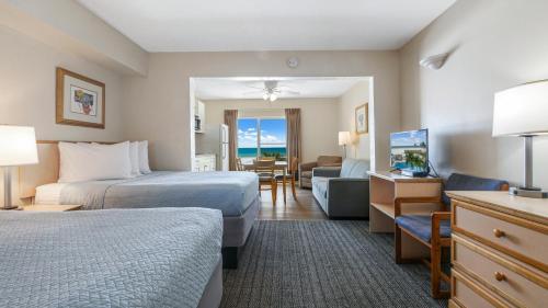 Palm Crest Resort Motel في سانت بيتي بيتش: غرفه فندقيه بسريرين وصاله