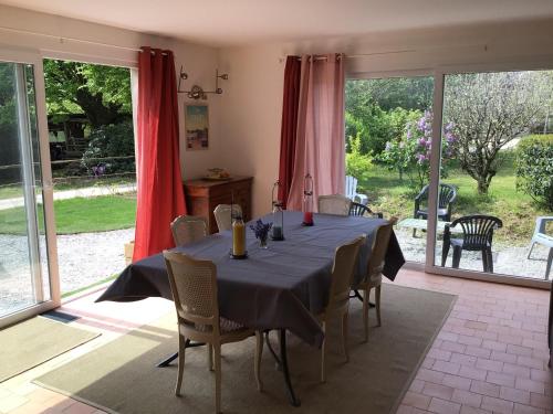 d'une salle à manger avec une table, des chaises et des portes coulissantes en verre. dans l'établissement Grande maison, calme, proche de la mer, à Camoël