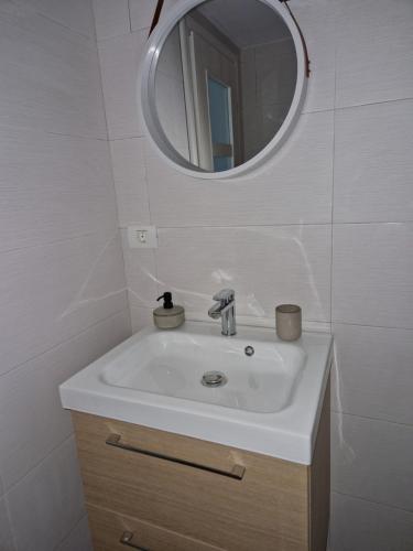 bagno con lavandino bianco e specchio di Bran Studio a Bran