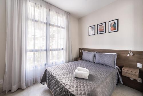 圣保罗Kaza Noah Residence Jacques Pilon的一间卧室配有一张床,上面有两条毛巾