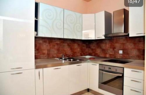 a kitchen with white cabinets and a sink at Villa Mare Apartments in Tivat