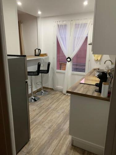 une cuisine avec un comptoir, un bureau et une fenêtre dans l'établissement Au Sunrise Studio, à Thonon-les-Bains