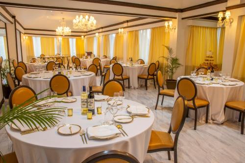 a banquet room with white tables and chairs at Sago Palm Hotel in Ocho Rios