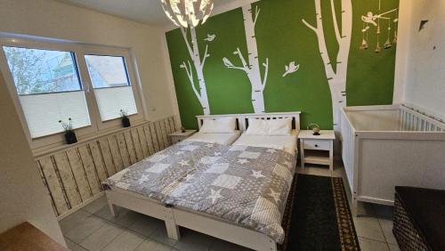ein Schlafzimmer mit einem Bett und an der Wand gemalten Bäumen in der Unterkunft Haus Kliffblick in Glowe