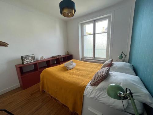 - une chambre avec un lit doté d'une couverture jaune et d'une fenêtre dans l'établissement -Pause Retro- T2 Centre Gare Wifi Lave Linge, à Quimper
