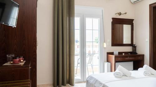a hotel room with a bed and a sliding glass door at Spilaio at Meteora in Kalabaka