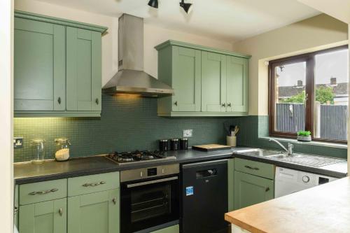 a kitchen with green cabinets and a stove top oven at Spacious 3 Bed House in Near A1, A19, Contractors, Free Parking 