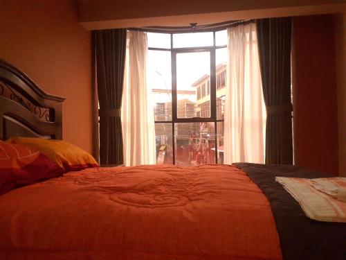 a bedroom with a bed and a large window at Hotel Casa Grande F&J in Potosí
