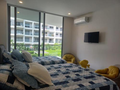 1 dormitorio con 2 camas y TV de pantalla plana en Apto morroszoe 217A, en Cartagena de Indias