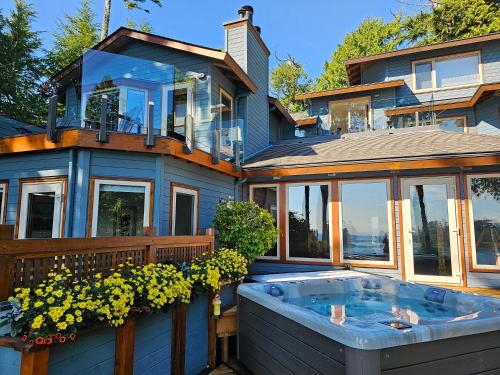 a house with a hot tub in the yard at Snug Harbour Inn in Ucluelet