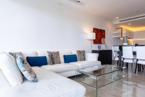 sala de estar con sofá blanco y mesa de cristal en Oceana 422 Playa del Carmen Condo, en Playa del Carmen