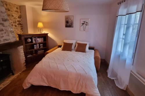 a bedroom with a large bed with white sheets at Le Pavillon bleu Vouvant - Gite Maison in Vouvant
