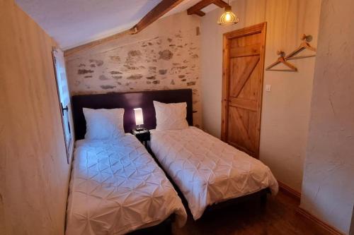 a bedroom with a bed and a wooden door at Le Pavillon bleu Vouvant - Gite Maison in Vouvant