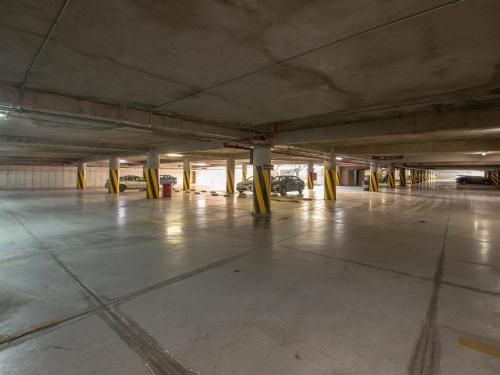 an empty parking lot with cars parked in a parking garage at Ramada Encore by Wyndham Queretaro in Querétaro
