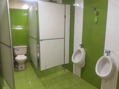 uma casa de banho com dois WC, um urinol e um lavatório em Hotel Casa Grande F&J em Potosí