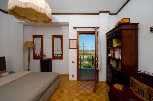 a bedroom with a bed and a door to a balcony at Archontiko Alexandros Luxury Suites in Kardiá