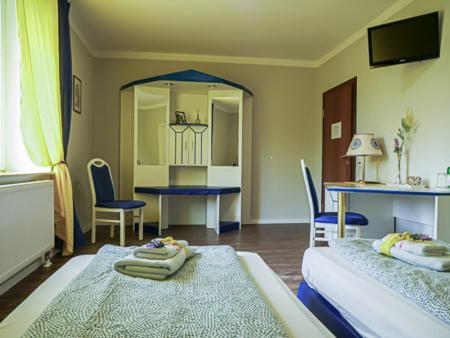 RadeburgにあるHotel & Ristorante Positanoのベッド2台、テーブル、椅子が備わる客室です。