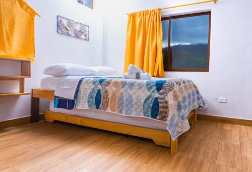 a bedroom with a bed and a window at Mindoxtrem Birds in Mindo